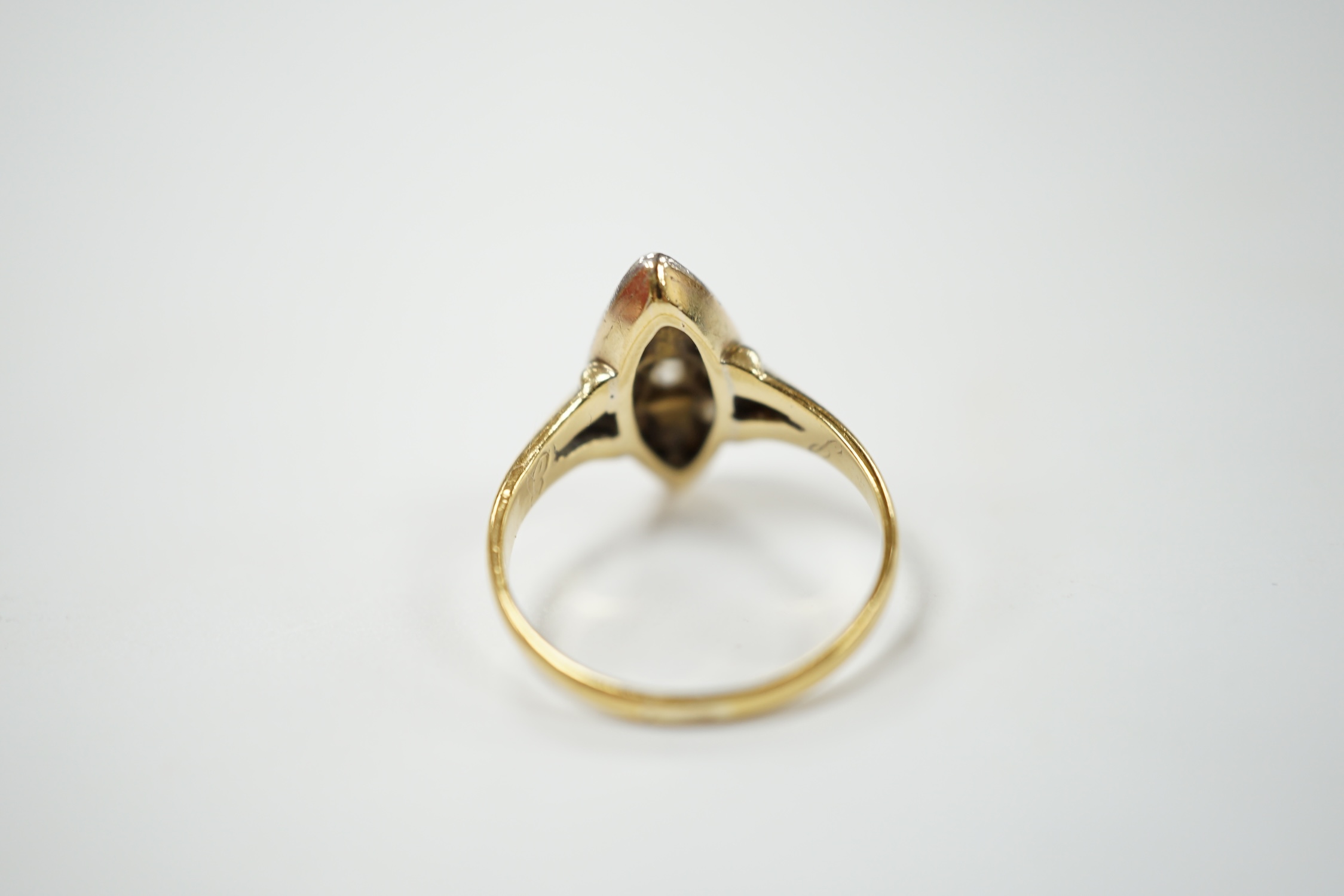 A yellow metal and diamond chip set marquise cluster ring, size K, gross weight 3 grams. Condition - fair